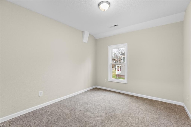carpeted spare room featuring baseboards and visible vents