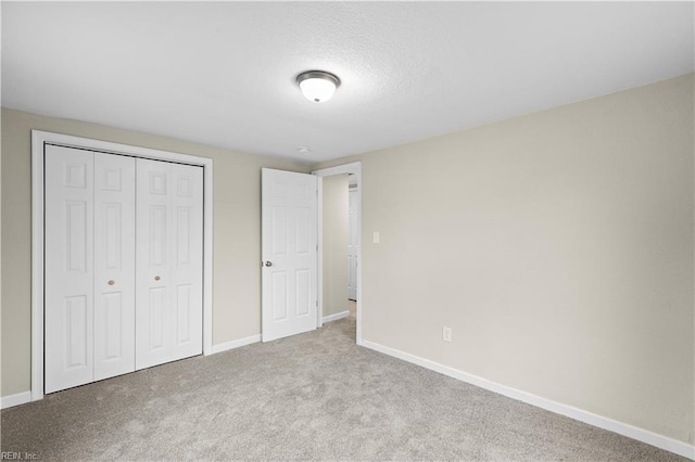 unfurnished bedroom featuring carpet, a closet, and baseboards