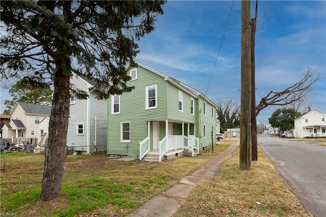 view of front of home with fence and a front lawn