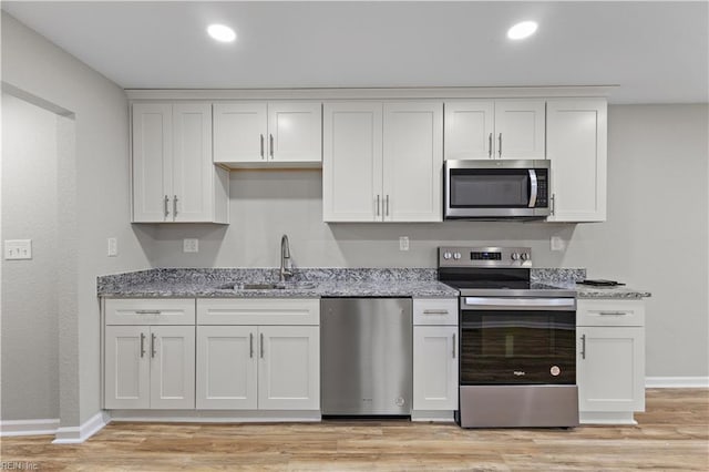 kitchen with a sink, white cabinets, and appliances with stainless steel finishes