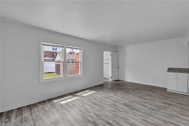 spare room featuring wood finished floors and baseboards