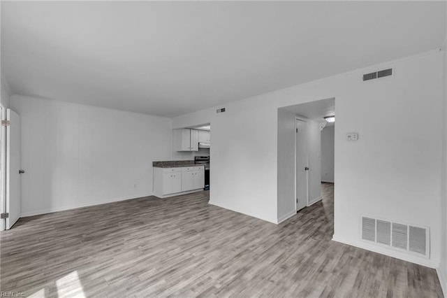 unfurnished living room with light wood-style flooring and baseboards