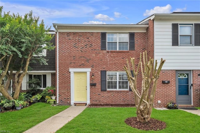multi unit property featuring a front yard and brick siding