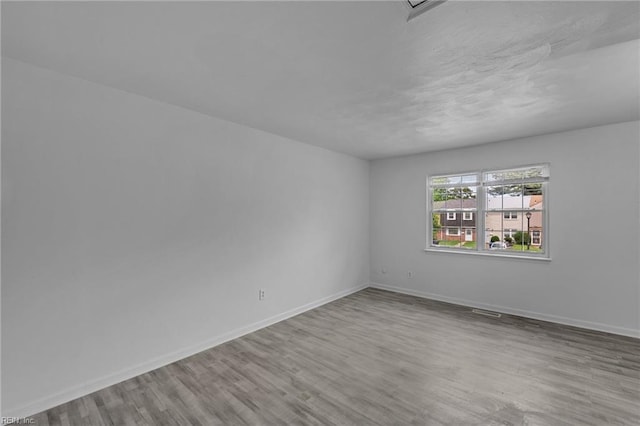 unfurnished room with wood finished floors and baseboards