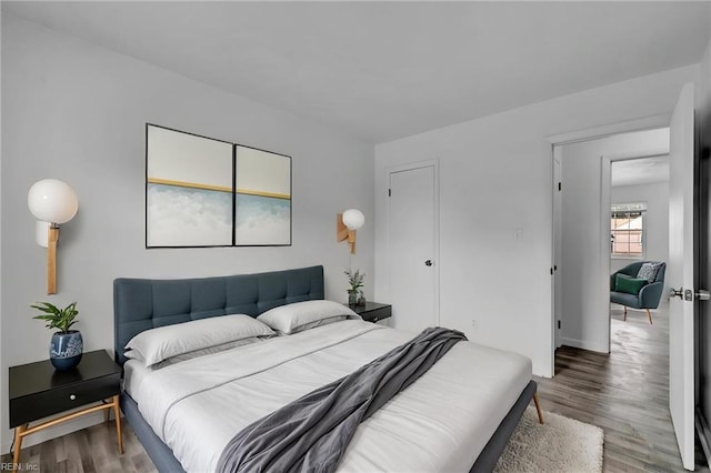 bedroom with wood finished floors and baseboards