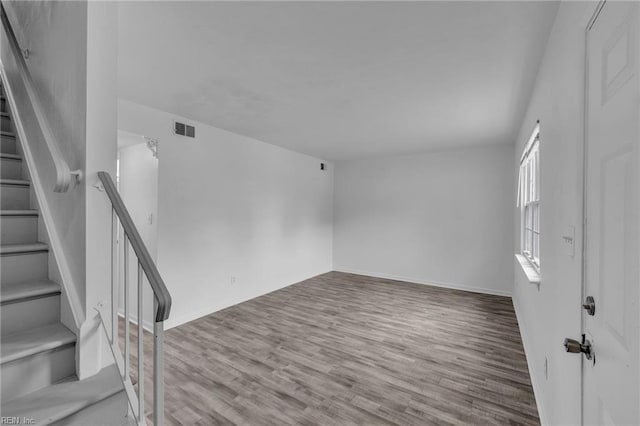 entryway featuring wood finished floors, stairs, and baseboards