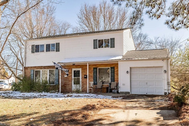 view of front facade with covered porch, a garage, and driveway