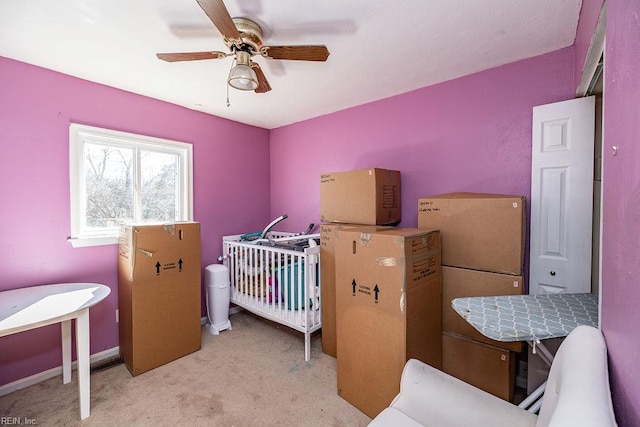 bedroom featuring ceiling fan, carpet, baseboards, and a crib