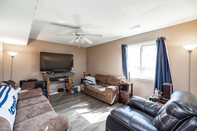 living room featuring visible vents, ceiling fan, and wood finished floors