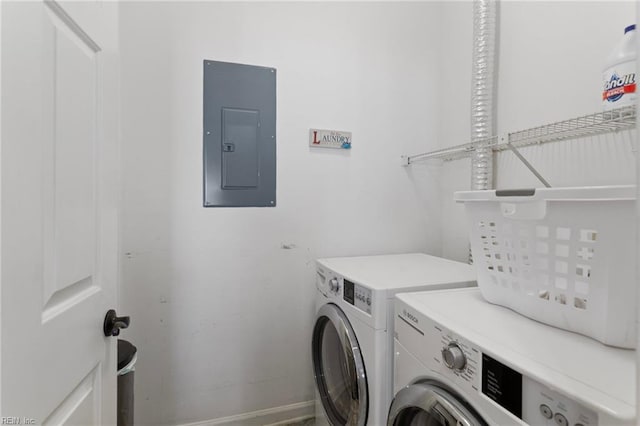 washroom with electric panel, laundry area, separate washer and dryer, and baseboards