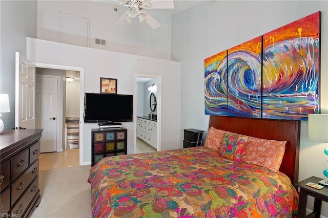 carpeted bedroom featuring a towering ceiling, a ceiling fan, and visible vents