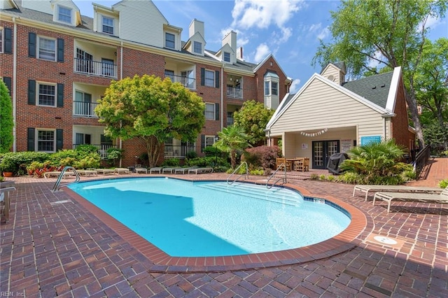 community pool with a patio area and french doors