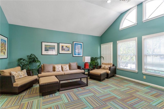 living area with light carpet, baseboards, and high vaulted ceiling