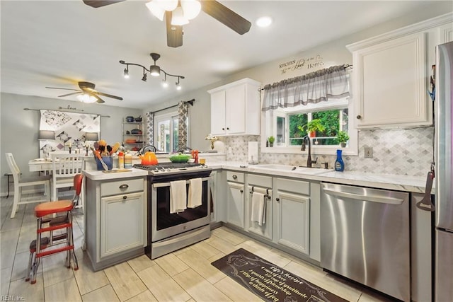 4757 Bunker Hill Ln, Virginia Beach, VA 23462 - kitchen featuring ceiling fan, a sink, a peninsula, decorative backsplash, and stainless steel appliances