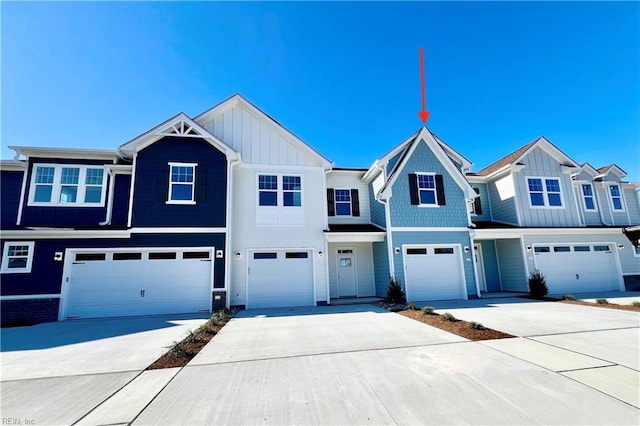 view of property with board and batten siding, driveway, and a garage