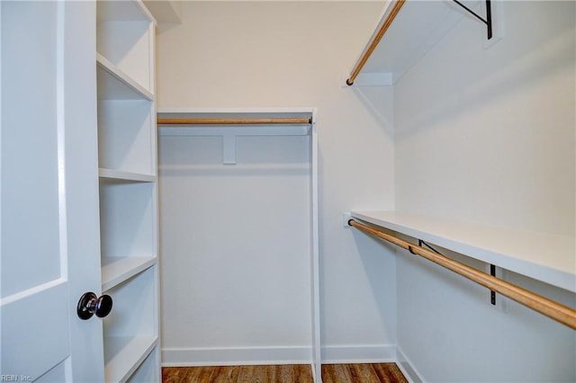 walk in closet with wood finished floors