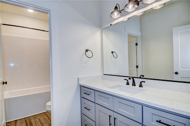 full bath featuring toilet, shower / bath combination, vanity, and wood finished floors