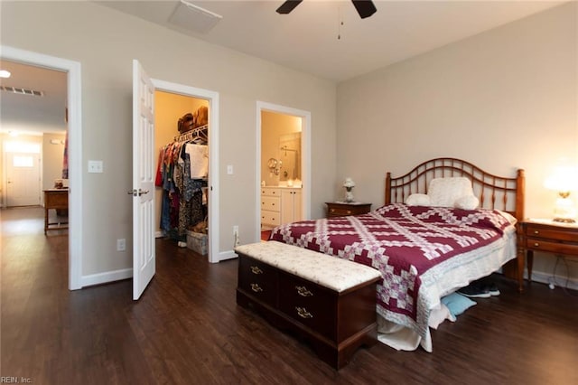 bedroom with baseboards, dark wood finished floors, a closet, and a walk in closet