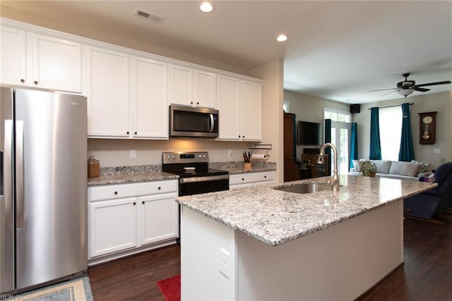 kitchen with a sink, stainless steel appliances, white cabinetry, and visible vents