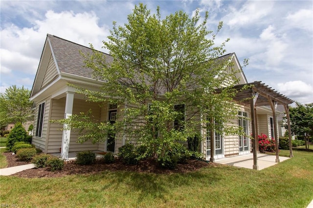 view of front facade featuring a shingled roof, a patio area, a pergola, and a front yard