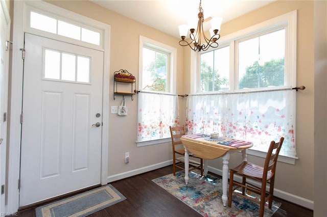 entryway with dark wood-style flooring, a chandelier, and baseboards