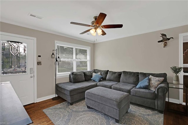 living area featuring wood finished floors, a ceiling fan, baseboards, and ornamental molding