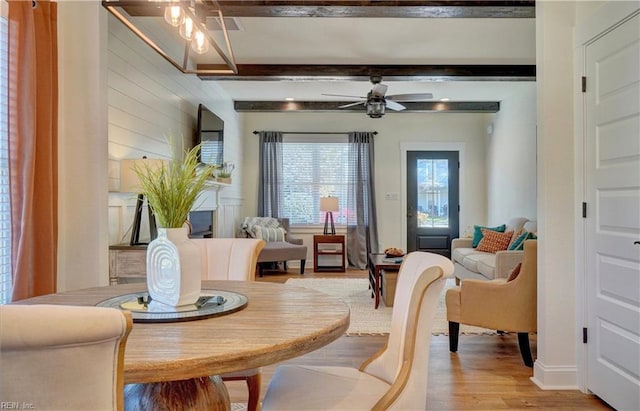 interior space with ceiling fan, beamed ceiling, and light wood-style floors