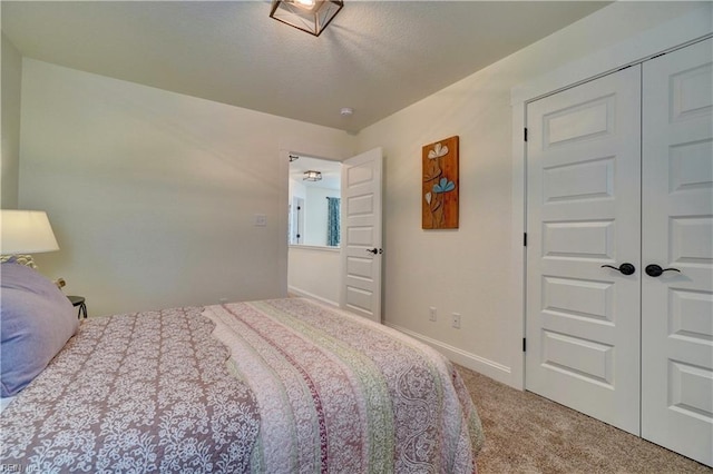 carpeted bedroom with baseboards and a closet