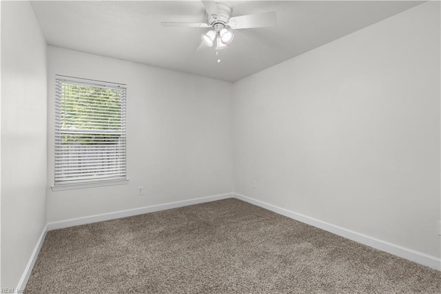 carpeted empty room featuring baseboards and a ceiling fan