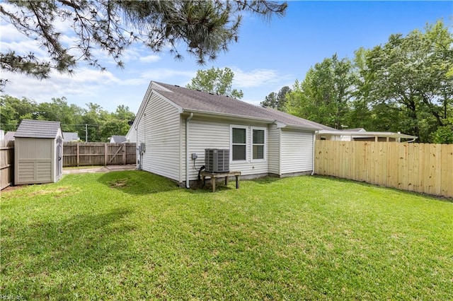 back of property with a storage shed, cooling unit, and an outbuilding