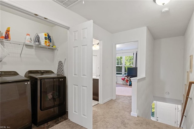 clothes washing area with separate washer and dryer, carpet flooring, and baseboards