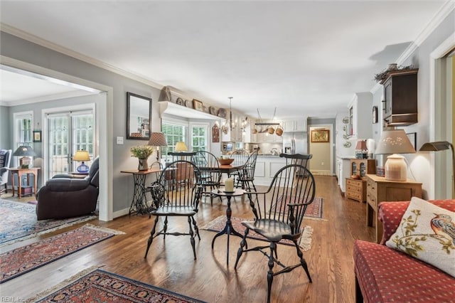 dining room with ornamental molding, light wood-style flooring, baseboards, and a chandelier