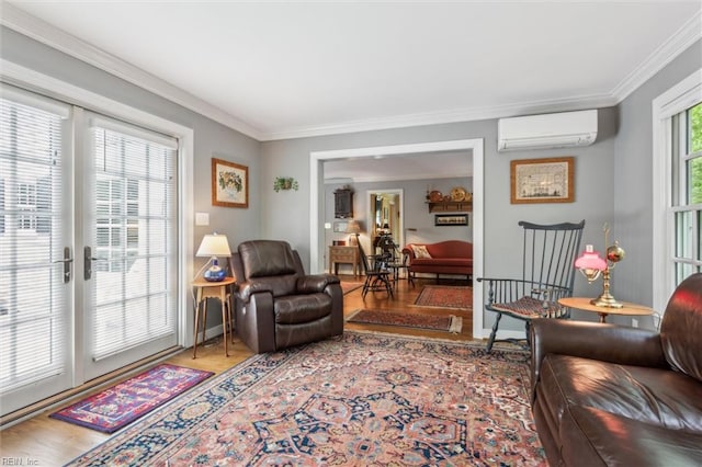 living room featuring a wall mounted AC, wood finished floors, crown molding, and baseboards