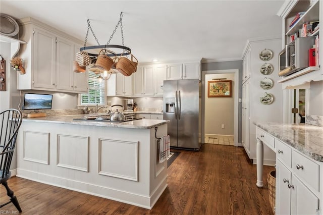 kitchen featuring stainless steel refrigerator with ice dispenser, a peninsula, dark wood-type flooring, baseboards, and crown molding