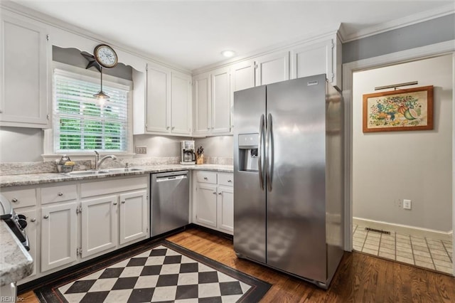 kitchen with stainless steel appliances, a sink, white cabinetry, and ornamental molding