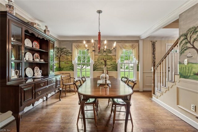 dining space featuring a chandelier, light wood finished floors, crown molding, stairway, and a decorative wall