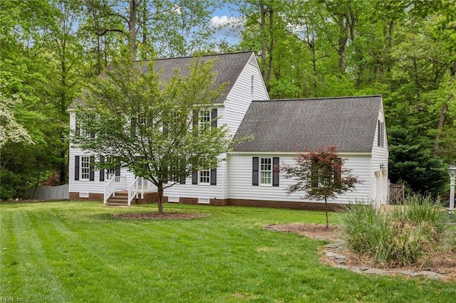 rear view of property with a shingled roof and a yard