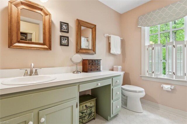 full bath featuring vanity, toilet, tile patterned floors, and baseboards