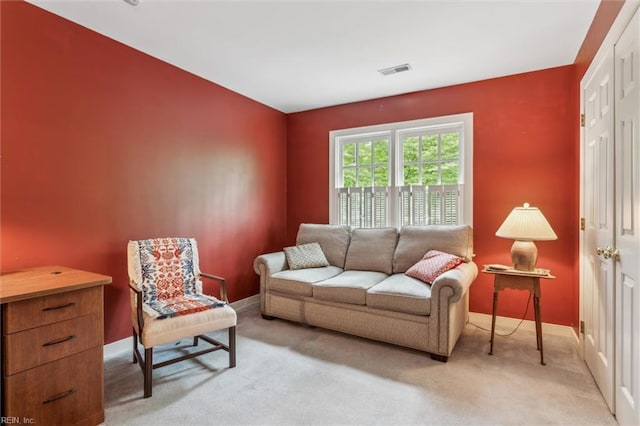 living area featuring baseboards and light colored carpet