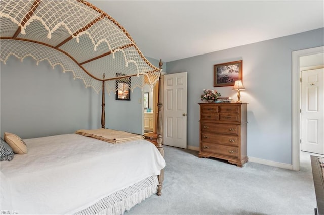carpeted bedroom with baseboards and connected bathroom
