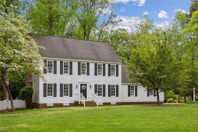 colonial-style house featuring roof with shingles