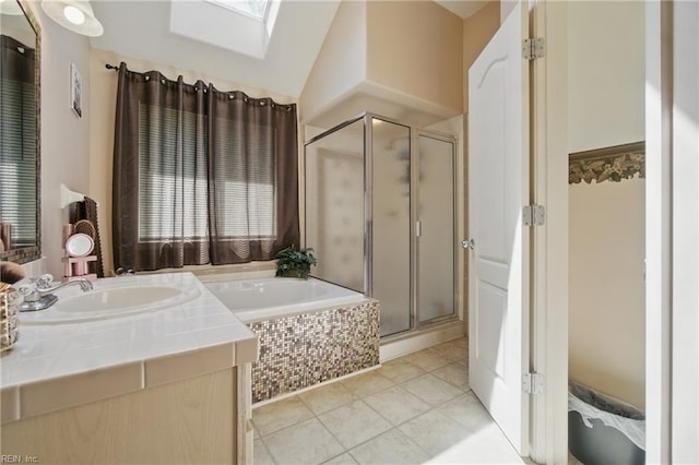 bathroom featuring tile patterned flooring, a stall shower, a skylight, a bath, and vanity