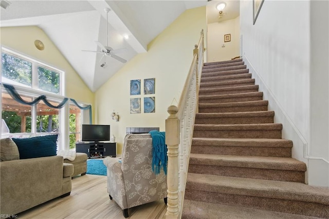 staircase featuring ceiling fan, wood finished floors, and high vaulted ceiling