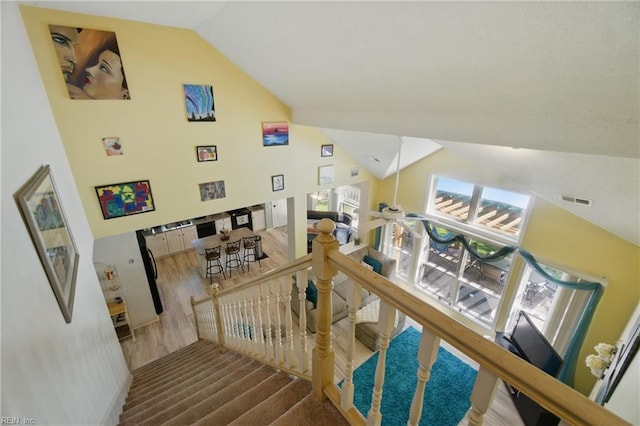 staircase with high vaulted ceiling