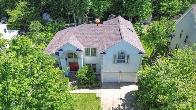 view of front of home with stucco siding, an attached garage, and driveway