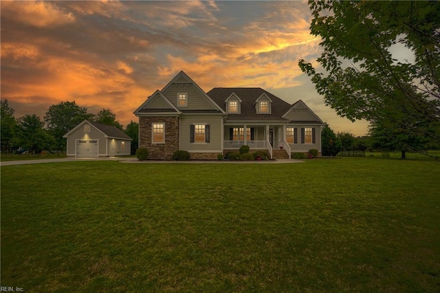view of front of property with a garage, an outbuilding, a porch, a front lawn, and driveway