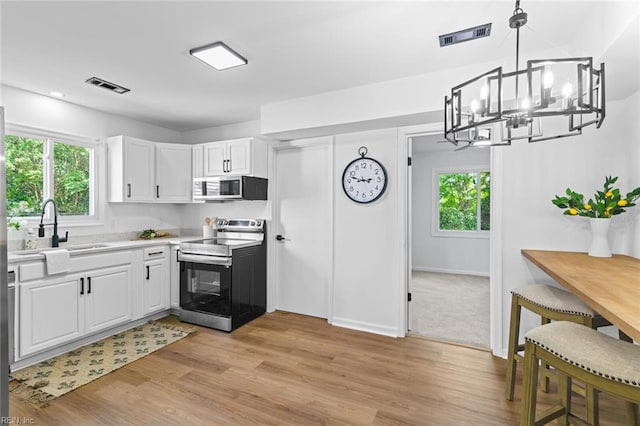 728 23rd St, Newport News, VA 23607 - kitchen with appliances with stainless steel finishes, visible vents, light wood-style flooring, and a notable chandelier