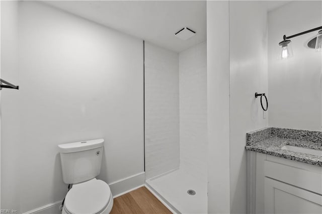 325 S Main St, Suffolk, VA 23434 - full bathroom featuring baseboards, toilet, a tile shower, vanity, and wood finished floors