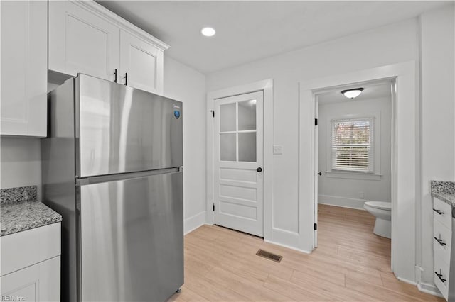 325 S Main St, Suffolk, VA 23434 - kitchen featuring freestanding refrigerator, white cabinets, visible vents, baseboards, and light wood-style floors