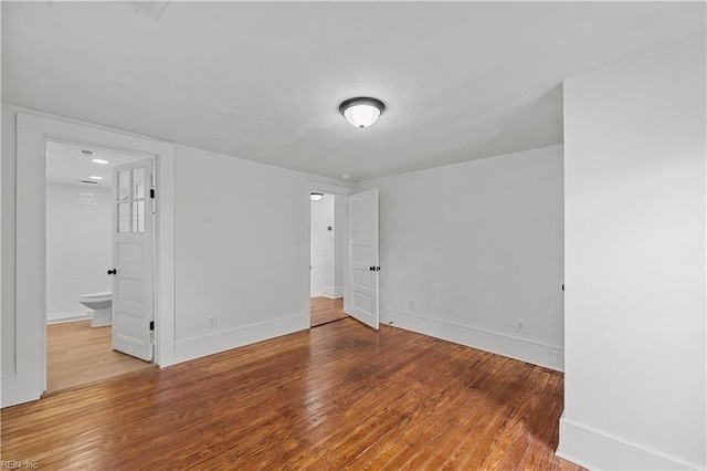 325 S Main St, Suffolk, VA 23434 - unfurnished bedroom featuring ensuite bathroom, baseboards, and wood finished floors